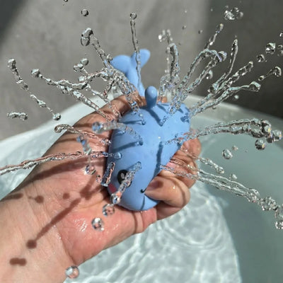 PureRain Splash Buddy blue whale water squirter toy for kids bath time being squirted so water is being sprayed.
