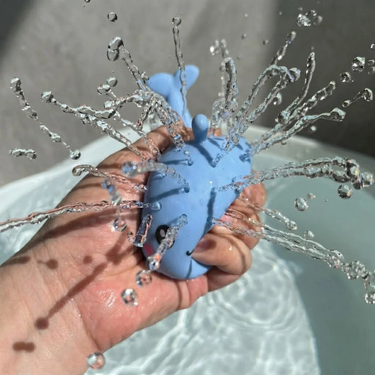 PureRain Splash Buddy blue whale water squirter toy for kids bath time being squirted so water is being sprayed.