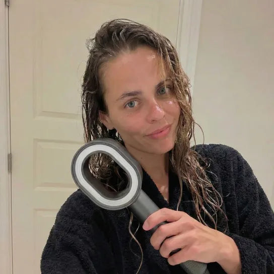 Woman who's got wet hair holding the PureRain Halo filtered showerhead