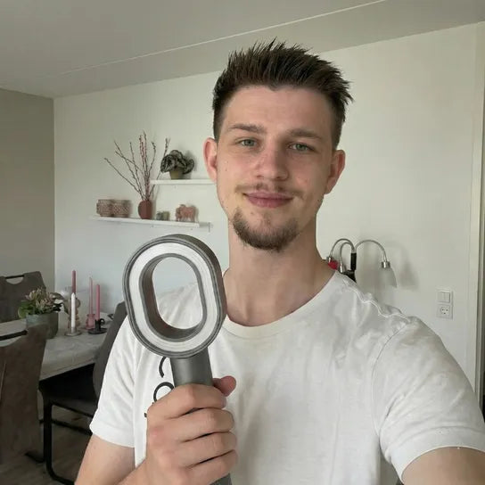 Scandinavian looking man smiling holding the PureRain Halo filtered showerhead