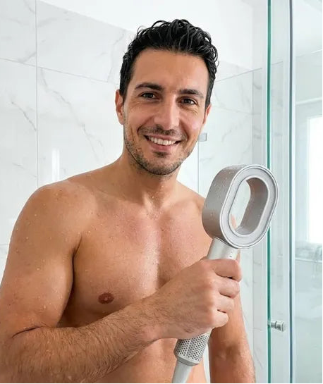 Man smiling holding the PureRain Halo filtered showerhead in the shower